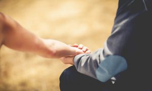 Close up of young loving couple holding hands. Vintage filter an