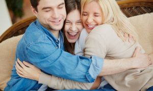 familia-alegre-abrazandose-en-el-sofa_1098-3601
