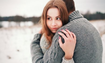 primer-plano-de-mujer-rubia-abrazando-a-su-novio-en-el-prado-nevado_1140-359