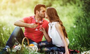 pareja-besandose-y-sujetando-unas-copas-de-vino_1153-1395