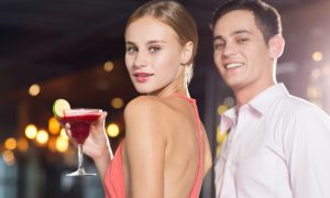 sonriendo-pareja-joven-y-coctel-en-la-fiesta-del-primer_1262-1624