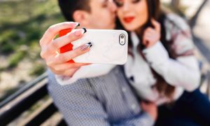 primer-plano-de-mano-sujetando-un-movil-blanco_1153-391