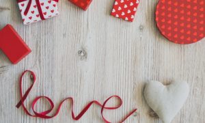 cajas-de-regalo-sobre-una-mesa-de-madera-con-la-palabra-love-y-un-corazon_23-2147593342