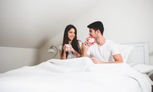pareja-bebiendo-de-unas-tazas-de-cafe-en-la-cama_23-2147595887