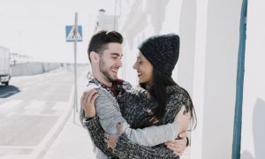 pareja-joven-abrazandose-al-lado-de-calle_23-2147732033